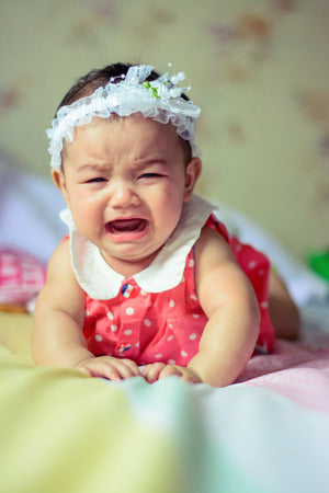 Baby wearing headband crying